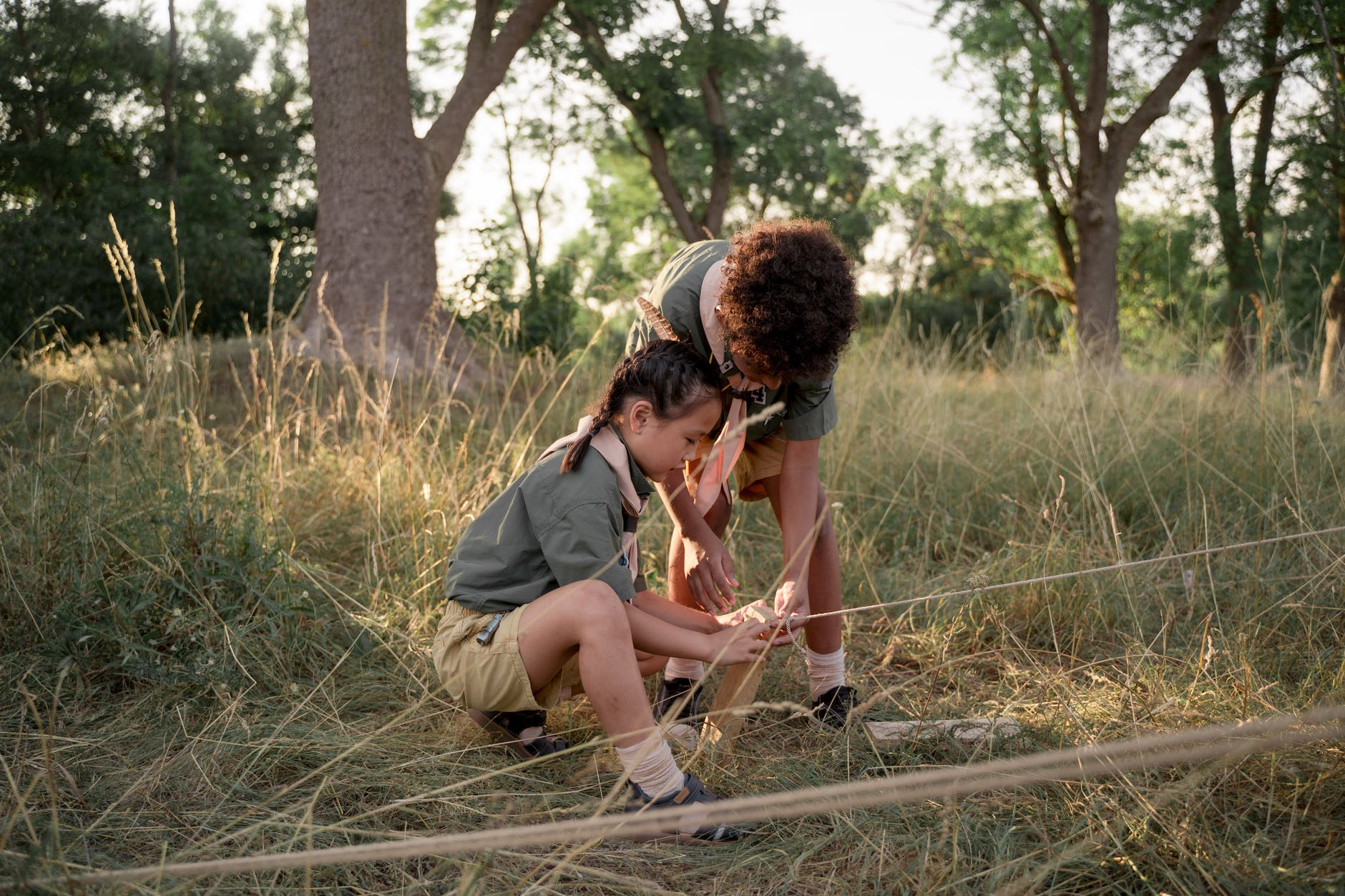 young scouts tying a rope to a planted wood